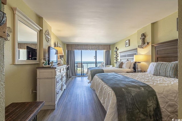 bedroom featuring access to exterior and dark hardwood / wood-style flooring