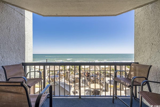 balcony with a water view and a beach view