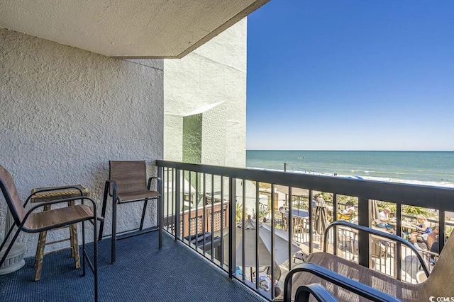 balcony featuring a beach view and a water view