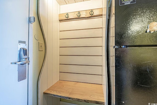 mudroom featuring wood walls