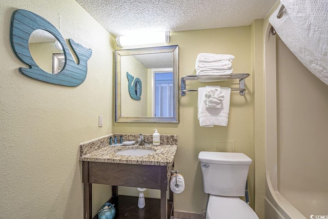 bathroom featuring toilet, sink, and a textured ceiling