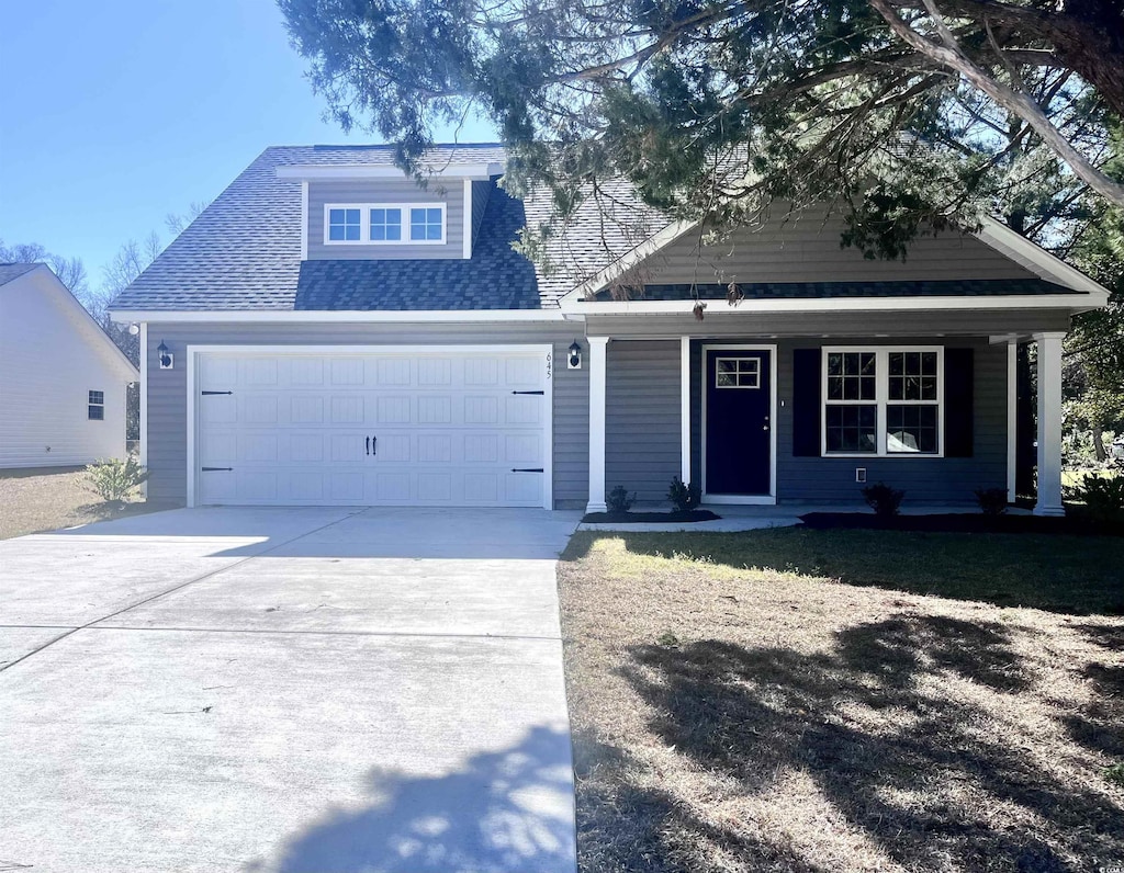 craftsman inspired home with a porch, a front yard, and a garage