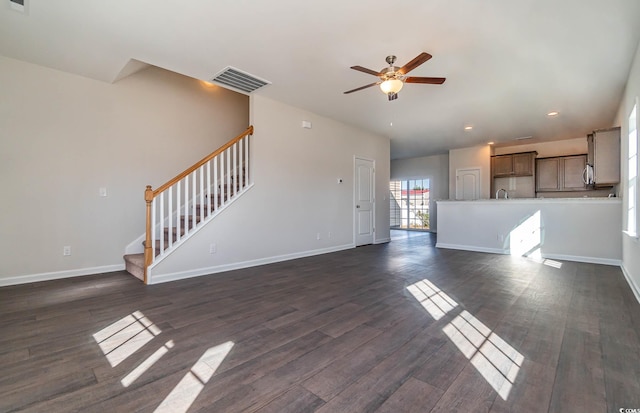 unfurnished living room with ceiling fan, sink, and dark wood-type flooring