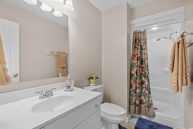 bathroom with vanity, a shower with shower curtain, and toilet