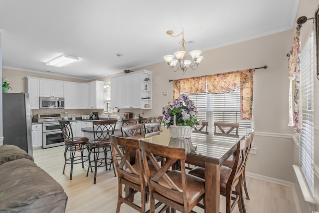 dining area with ornamental molding, sink, light hardwood / wood-style flooring, and an inviting chandelier