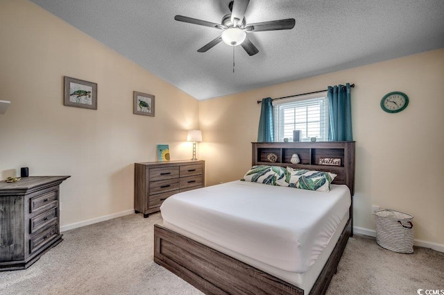 carpeted bedroom with lofted ceiling, a textured ceiling, and ceiling fan