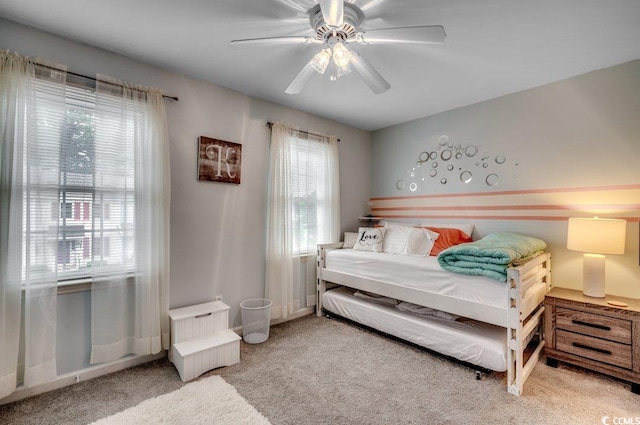 bedroom with multiple windows, light colored carpet, and ceiling fan