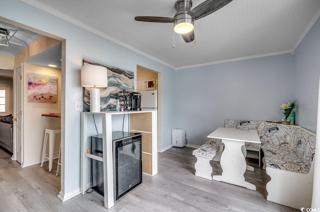 interior space with crown molding, wine cooler, ceiling fan, and light hardwood / wood-style floors