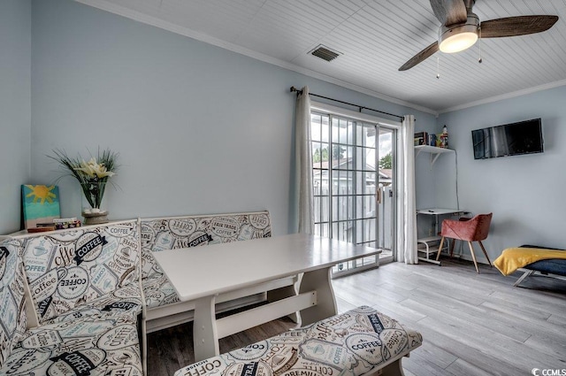 living room with ornamental molding, light hardwood / wood-style floors, and ceiling fan