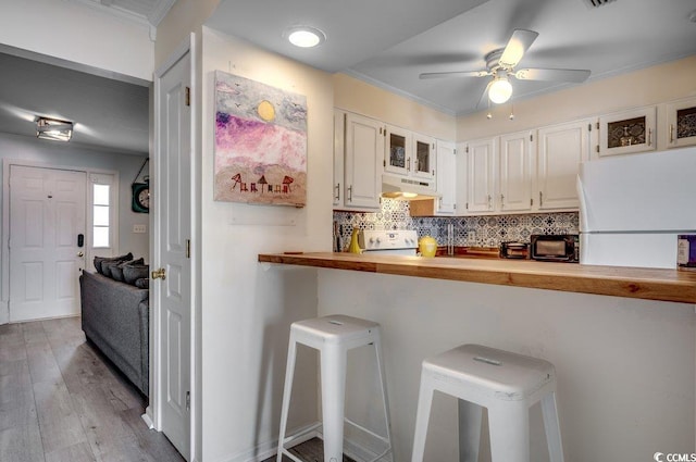 kitchen with light hardwood / wood-style flooring, ceiling fan, butcher block counters, backsplash, and white cabinets