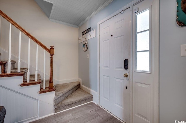 entryway with crown molding and light hardwood / wood-style floors