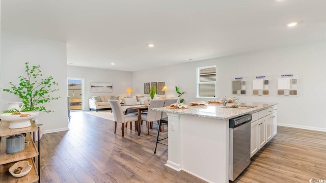 kitchen featuring dishwasher, a kitchen island with sink, white cabinets, sink, and light hardwood / wood-style flooring