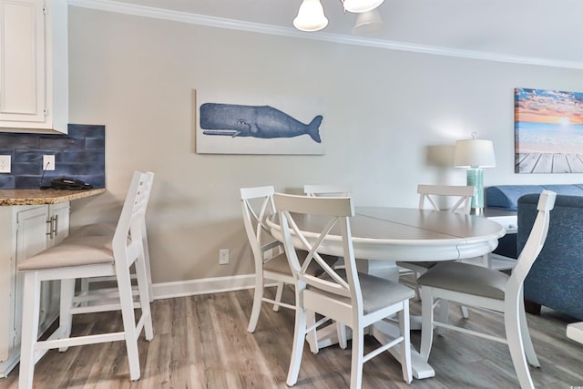 dining space with wood finished floors, baseboards, and ornamental molding