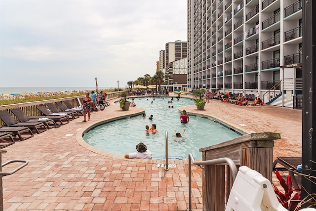 view of swimming pool with a water view and a patio