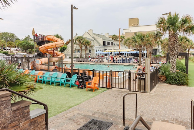 view of swimming pool with a water slide and a patio