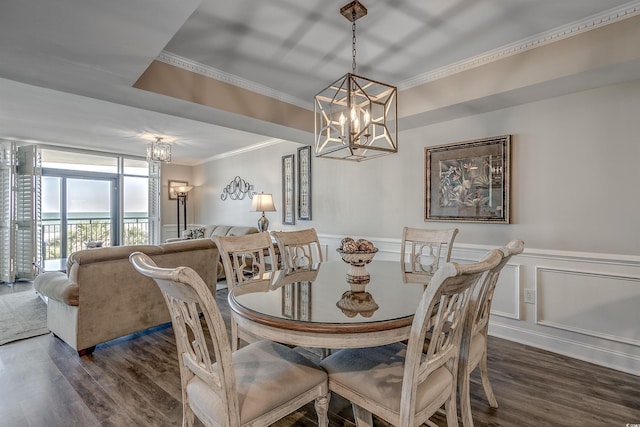 dining area with ornamental molding, dark wood-style flooring, wainscoting, and a notable chandelier