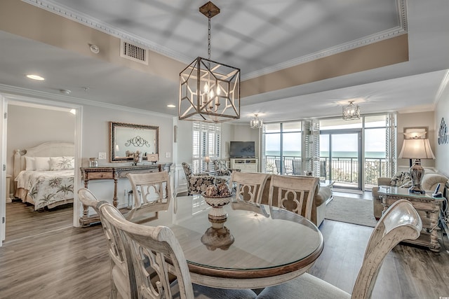 dining area featuring a chandelier, recessed lighting, wood finished floors, visible vents, and ornamental molding