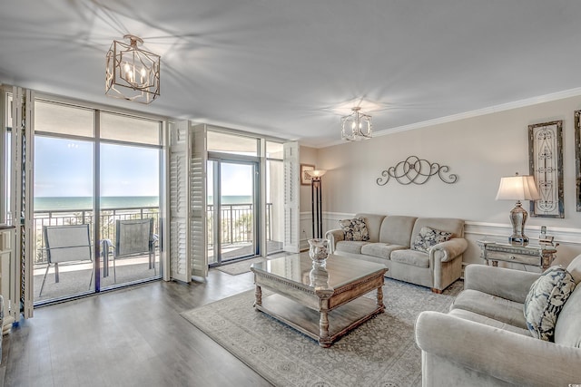 living area featuring wood finished floors, floor to ceiling windows, crown molding, and an inviting chandelier