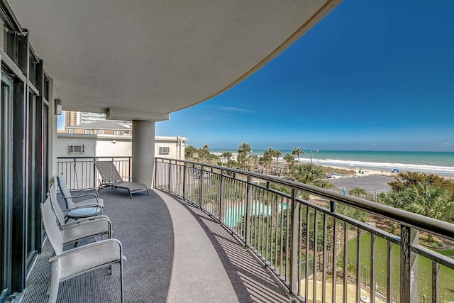 balcony featuring a water view and a view of the beach