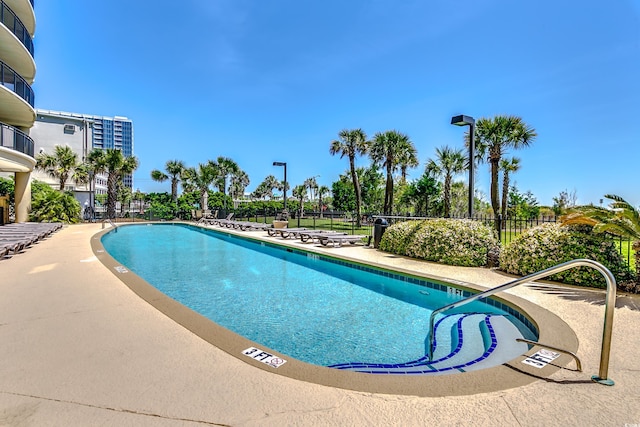 pool featuring fence and a patio