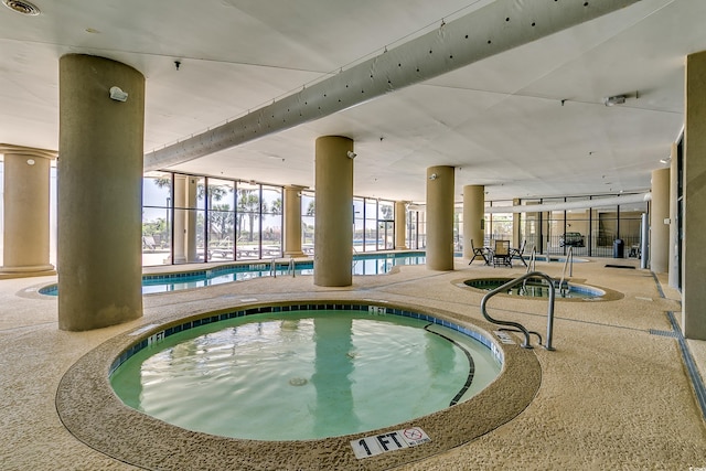 community pool featuring an indoor hot tub and a patio