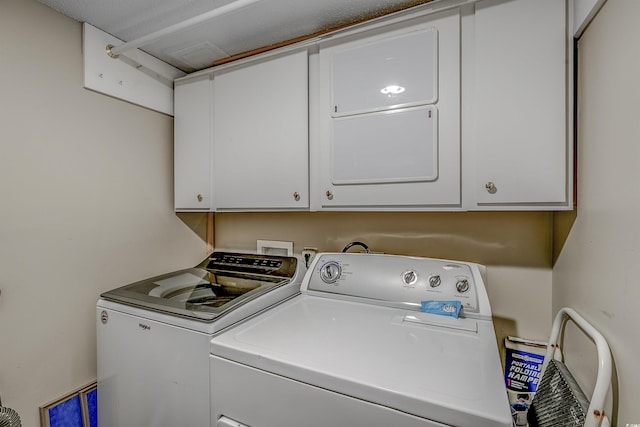 washroom featuring independent washer and dryer and cabinet space