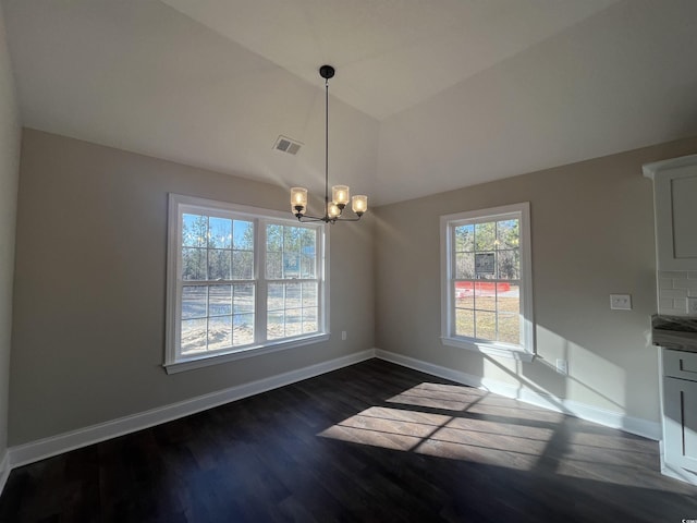 unfurnished dining area with vaulted ceiling, dark wood-type flooring, and a notable chandelier