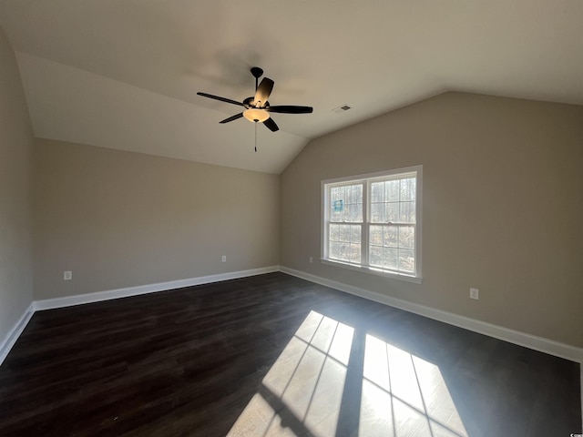 empty room with vaulted ceiling, dark wood-type flooring, and ceiling fan