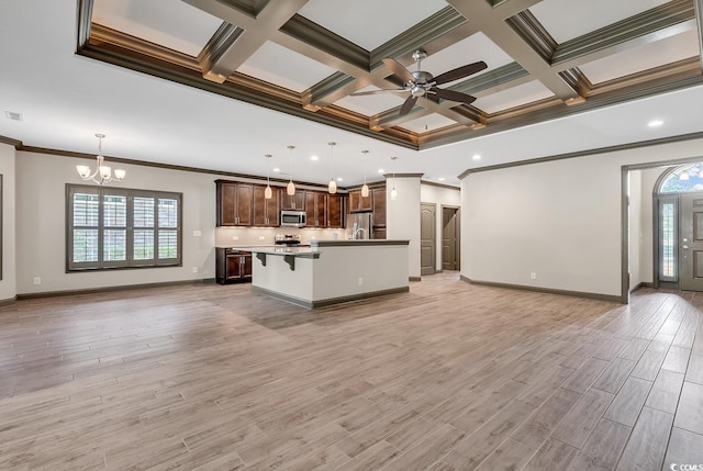 kitchen with a kitchen breakfast bar, an island with sink, pendant lighting, light wood-type flooring, and appliances with stainless steel finishes