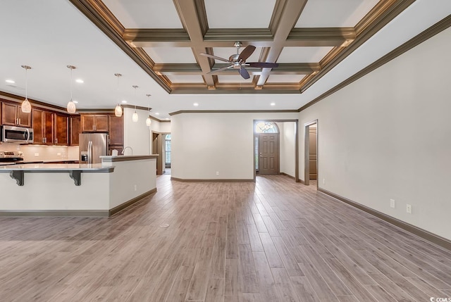 kitchen with appliances with stainless steel finishes, a kitchen breakfast bar, light hardwood / wood-style flooring, ornamental molding, and pendant lighting