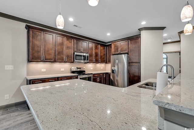 kitchen with stainless steel appliances, ornamental molding, dark brown cabinetry, decorative light fixtures, and light stone counters