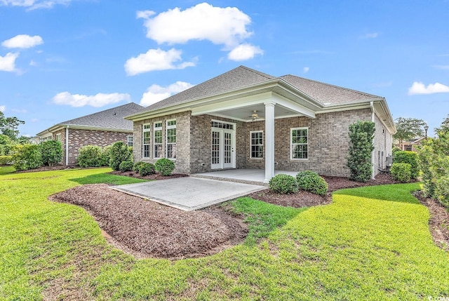 rear view of house featuring french doors, a patio, and a lawn