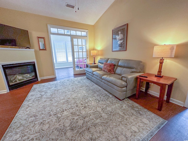 carpeted living room with a textured ceiling and vaulted ceiling