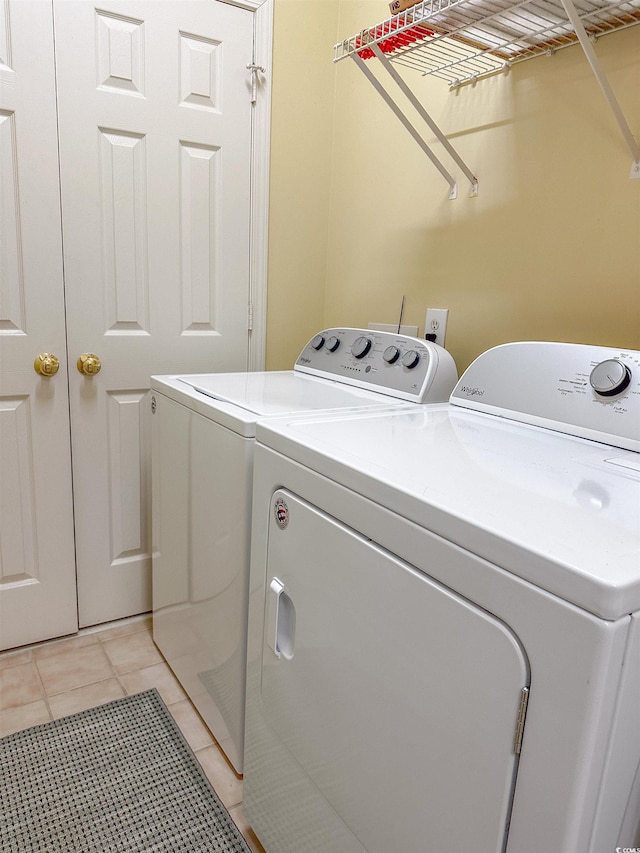 laundry room with light tile patterned floors and washing machine and dryer