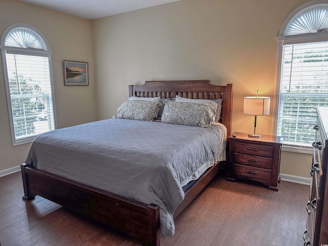 bedroom featuring a textured ceiling and dark wood-type flooring