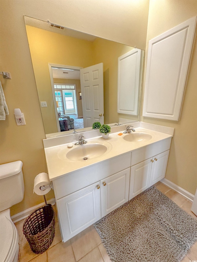 bathroom featuring tile patterned flooring, vanity, and toilet