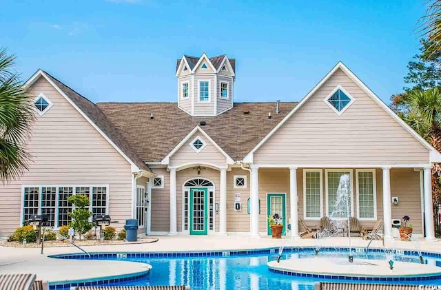 rear view of house with a community pool and a patio