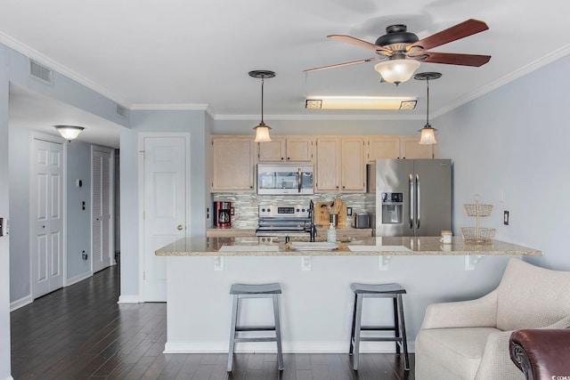 kitchen with appliances with stainless steel finishes, a breakfast bar area, crown molding, light stone countertops, and light brown cabinets