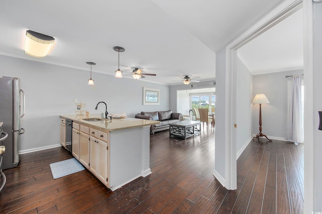 kitchen with light stone counters, sink, dark wood-type flooring, and stainless steel fridge