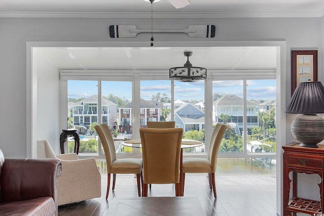 dining space with crown molding, a healthy amount of sunlight, and hardwood / wood-style floors