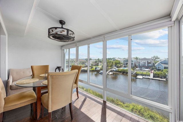 sunroom featuring a water view