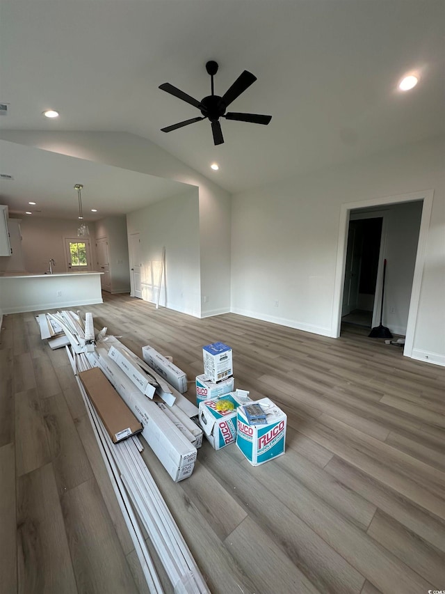 unfurnished living room featuring vaulted ceiling, hardwood / wood-style flooring, and ceiling fan