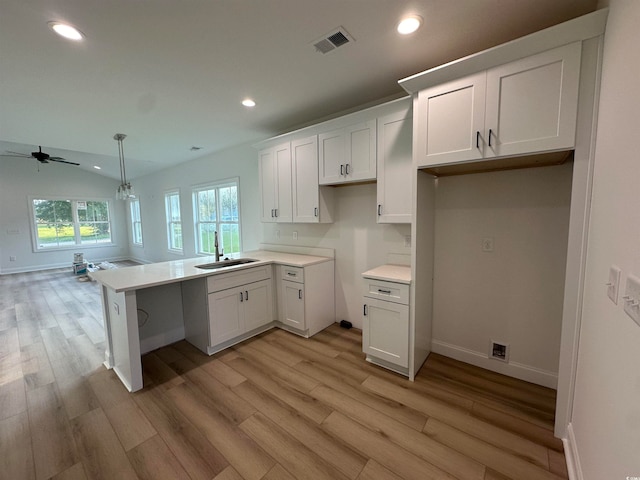 kitchen featuring white cabinets, ceiling fan, light hardwood / wood-style flooring, and kitchen peninsula