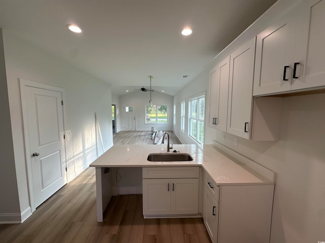 bathroom with hardwood / wood-style floors, sink, ceiling fan, and vaulted ceiling