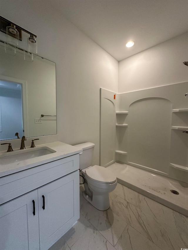 bathroom featuring walk in shower, vanity, and toilet