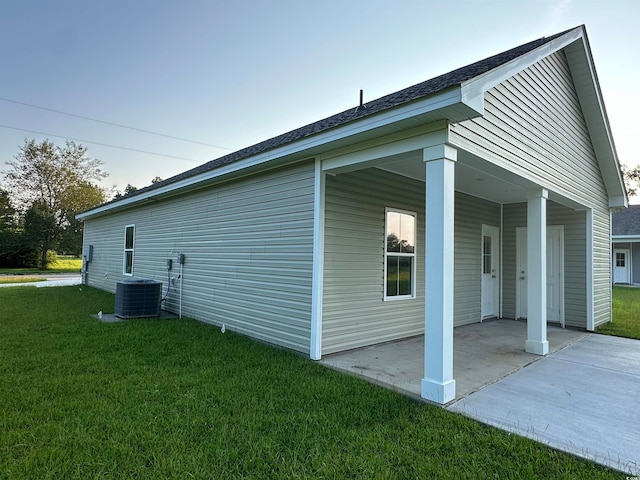 view of property exterior with central AC unit, a yard, and a patio area