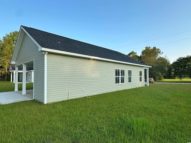 view of side of property featuring a patio and a yard