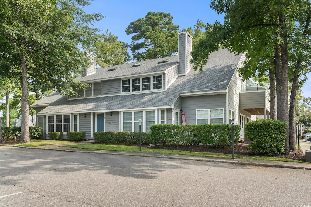 view of front of home featuring a shingled roof and a chimney