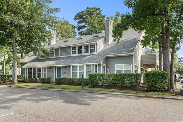 view of front of home featuring a shingled roof and a chimney