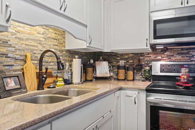 kitchen with white cabinetry, stainless steel appliances, and backsplash